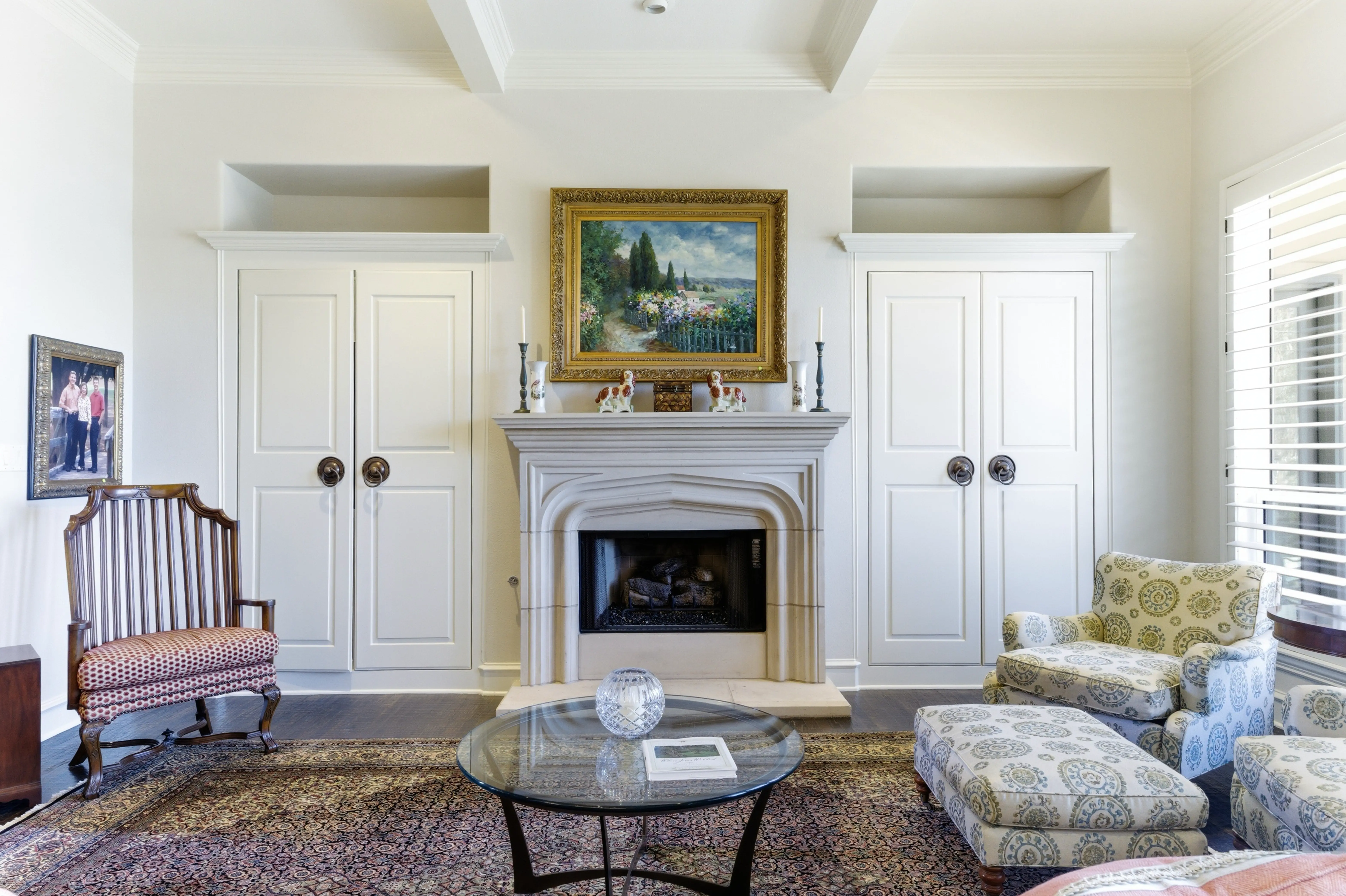 Living room with gas fireplace, built-in shelving, and plantation shutters